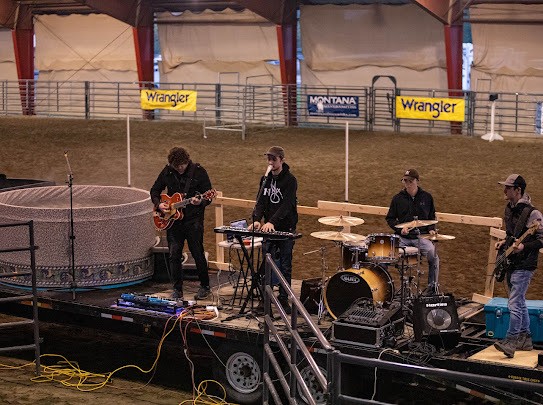 Worship band playing on a flatbed trailer stage inside an arena